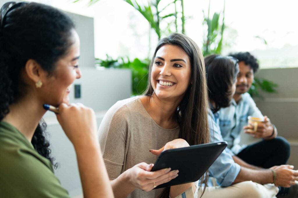 Woman with tablet discussing sales strategy and planning in co-working open space