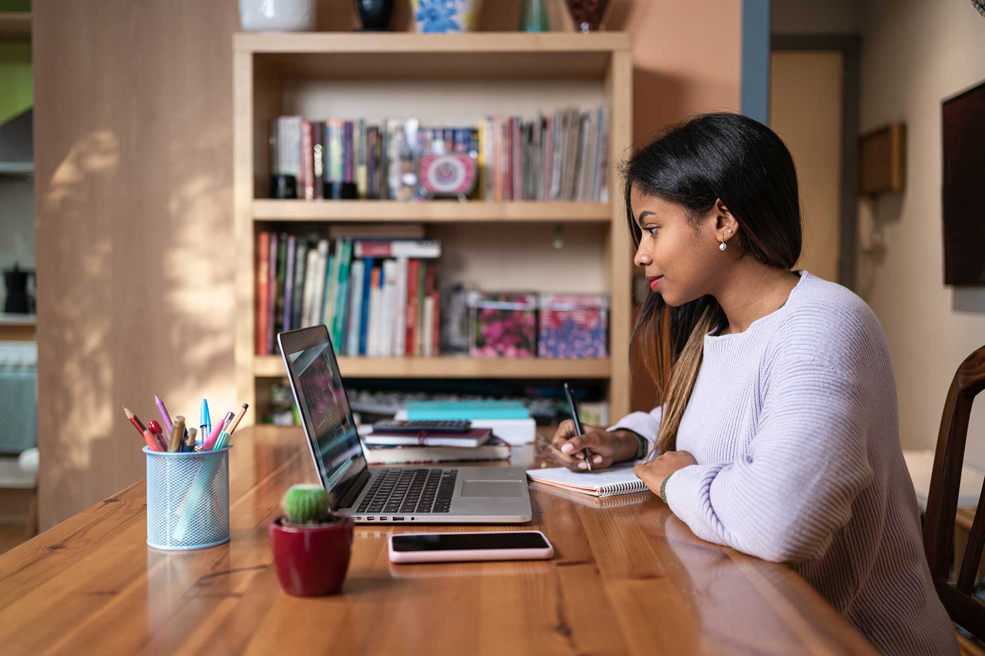 African American female student studying from online webinar or a course at home, video calling and talking